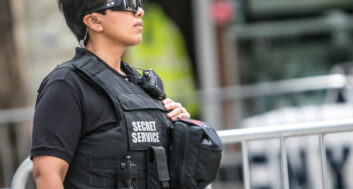 secret service agent wearing sunglasses and a protective vest