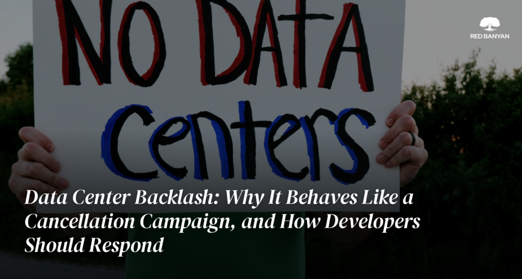 Protester holding a hand-lettered sign reading No Data Centers, with the Red Banyan logo and the blog title